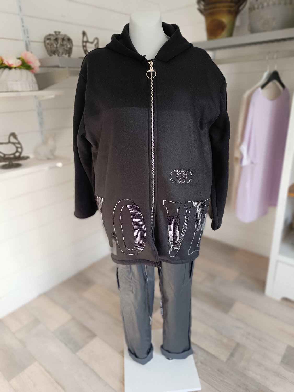Sweatjacke für Damen in Farbe Schwarz. Applikation aus Strasssteinchen. Reißverschluss und Kapuze.