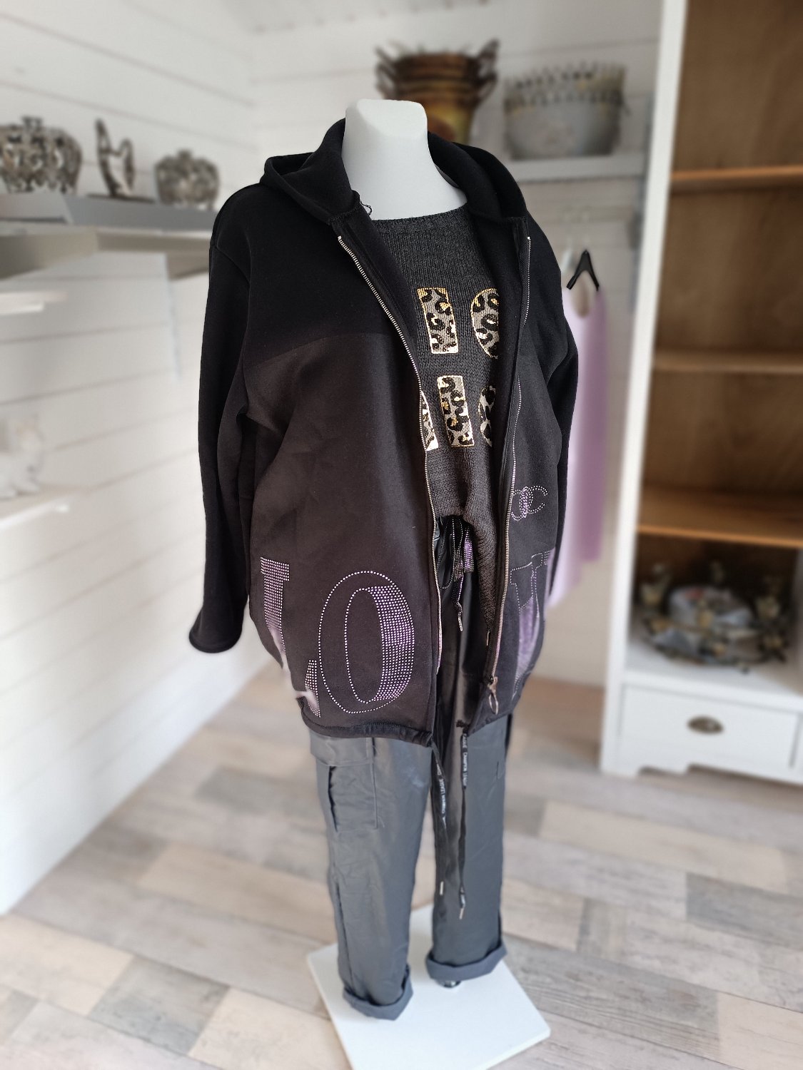 Sweatjacke mit Strass Love. Farbe Schwarz, Reißverschluss und Kapuze. Kordelzug zur zusätzlichen Weitenregulierung. Tragbar bis Größe 46/48.
